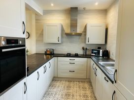 A kitchen with cabinets and appliances at Trearddur View in Treaddur Bay