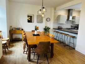 A dining room with a wooden table and chairs at Trearddur View in Treaddur Bay
