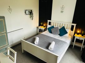 A bedroom with a bed and nightstands at Trearddur View in Treaddur Bay