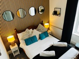 A bedroom with a bed and mirrors on the wall at Trearddur View in Treaddur Bay