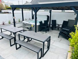 An outdoor area with a hot tub and seating at Trearddur View in Treaddur Bay
