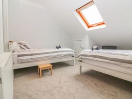 A bedroom with two single beds a small wooden stool and a skylight window at 7 The Retreat in Paignton