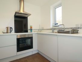 A kitchen with a kettle, oven, and sink at Little Pippin in Carlyon Bay near St Austell