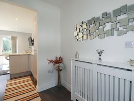 A hallway with a mirror and radiator cover at Little Pippin in Carlyon Bay near St Austell