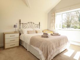 A bedroom with a bed and a bedside lamp at Little Pippin in Carlyon Bay near St Austell