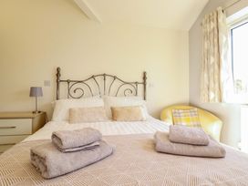 A bedroom with a bed and towels at Little Pippin in Carlyon Bay near St Austell