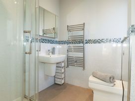 A bathroom with a shower, washbasin and toilet at Little Pippin Carlyon Bay near St Austell