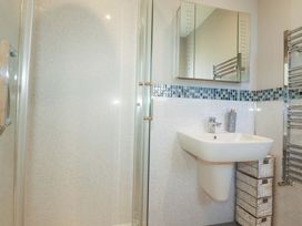 A bathroom with a shower and sink at Little Pippin in Carlyon Bay near St Austell