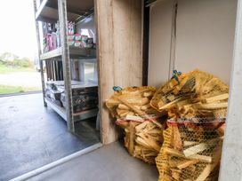 A storage room with shelves and bags of firewood at Stable Cottage in Staintondale