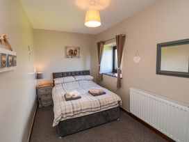 A bedroom with a bed and bedside table at Stable Cottage in Staintondale near Burniston
