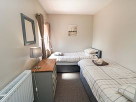 A bedroom with two beds and a dresser at Stable Cottage in Staintondale near Burniston
