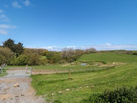 A field with a pond and trees at Stable Cottage in Staintondale near Burniston