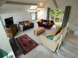 A living room with sofas, a coffee table, and a television at The Coach House in Llangollen