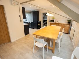 A dining room with a wooden table and chairs at The Coach House in Llangollen