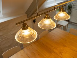 A dining room with pendant lights above a wooden table at The Coach House in Llangollen