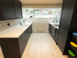 A kitchen with cabinets and appliances at The Coach House Llangollen