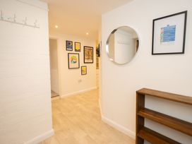 A hallway with hooks on the wall and framed pictures at The Coach House in Llangollen