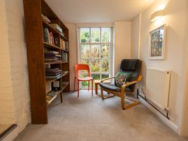A reading room with a bookshelf and seating area at The Coach House in Llangollen