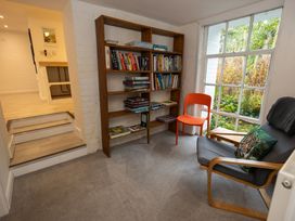 A snug with a bookshelf and chairs at The Coach House in Llangollen