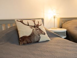 A bedroom with a deer print pillow and lamp at The Coach House Llangollen