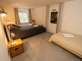 A bedroom with two beds and a window at The Coach House in Llangollen
