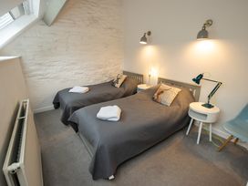 A bedroom with two single beds and decorative pillows at The Coach House in Llangollen