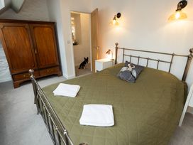 A bedroom with a bed and wardrobe at The Coach House in Llangollen