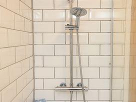 A shower with chrome fixtures in a bathroom at The Coach House in Llangollen