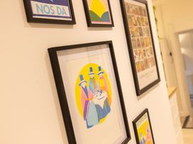 A wall with framed artwork at The Coach House in Llangollen