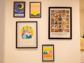 A collection of framed art prints on a wall at The Coach House in Llangollen