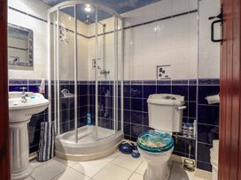 A bathroom with a shower enclosure sink and toilet at Hafoty Boeth Cottage in Corwen