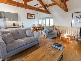 A living room with a sofa and dining area at Apple Tree Cottage Bleatarn near Kirkby Stephen