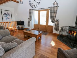 A living room with a sofa and television at Apple Tree Cottage in Bleatarn near Kirkby Stephen