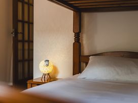 A bedroom with a bed and a lamp on the nightstand at Blueberry Cottage in Akeld near Wooler