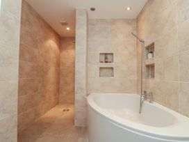 A bathroom with a bathtub and shower area at Apartment 6 in Whitby