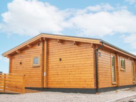 A wooden house with windows and decking at Manor Farm Lodges - Dragon Lodge, Newtown