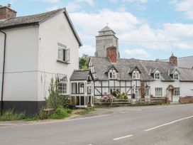 A house and church tower on a street at Manor Farm Lodges - Dragon Lodge in Newtown
