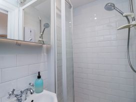 A shower and sink area in a bathroom at Lily Cottage in Looe