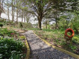 A pathway with gravel and flowers in a garden at Lily Cottage in Looe