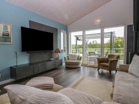 A living room with a tv and sofa at Links View in Fritton