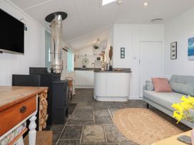 A living room with a stove and sofa at Smugglers Cottage in Trebarwith Strand near Tintagel