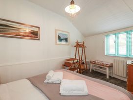 A bedroom with a bed and artwork at Smugglers Cottage in Trebarwith Strand near Tintagel