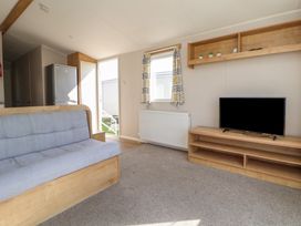 A living room with a sofa and television at K2 Static Caravan 