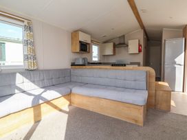 A living room with a couch and kitchen units at K2 Static Caravan in 