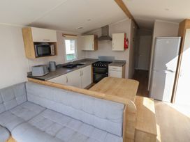 A kitchen with appliances and seating area in K2 Static Caravan