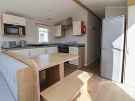 A kitchen with a dining table and appliances at K2 Static Caravan