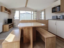 A living room with furniture including a table and television at K2 Static Caravan in 