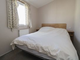 A bedroom with a bed and window at K2 Static Caravan