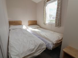 A bedroom with two single beds and a window at K2 Static Caravan