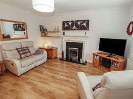 A living room with a fireplace and television at Riverside Cottage in Cockermouth